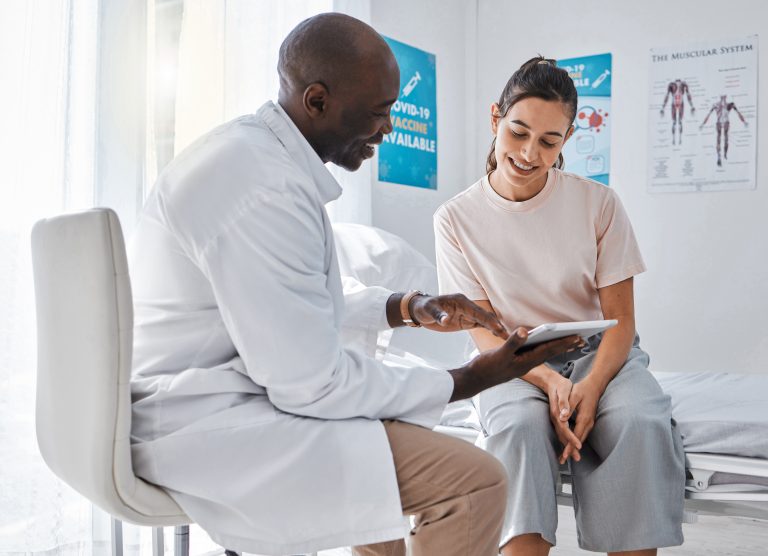 Doctor appointment or healthcare professional consulting a woman and explaining health using a table.