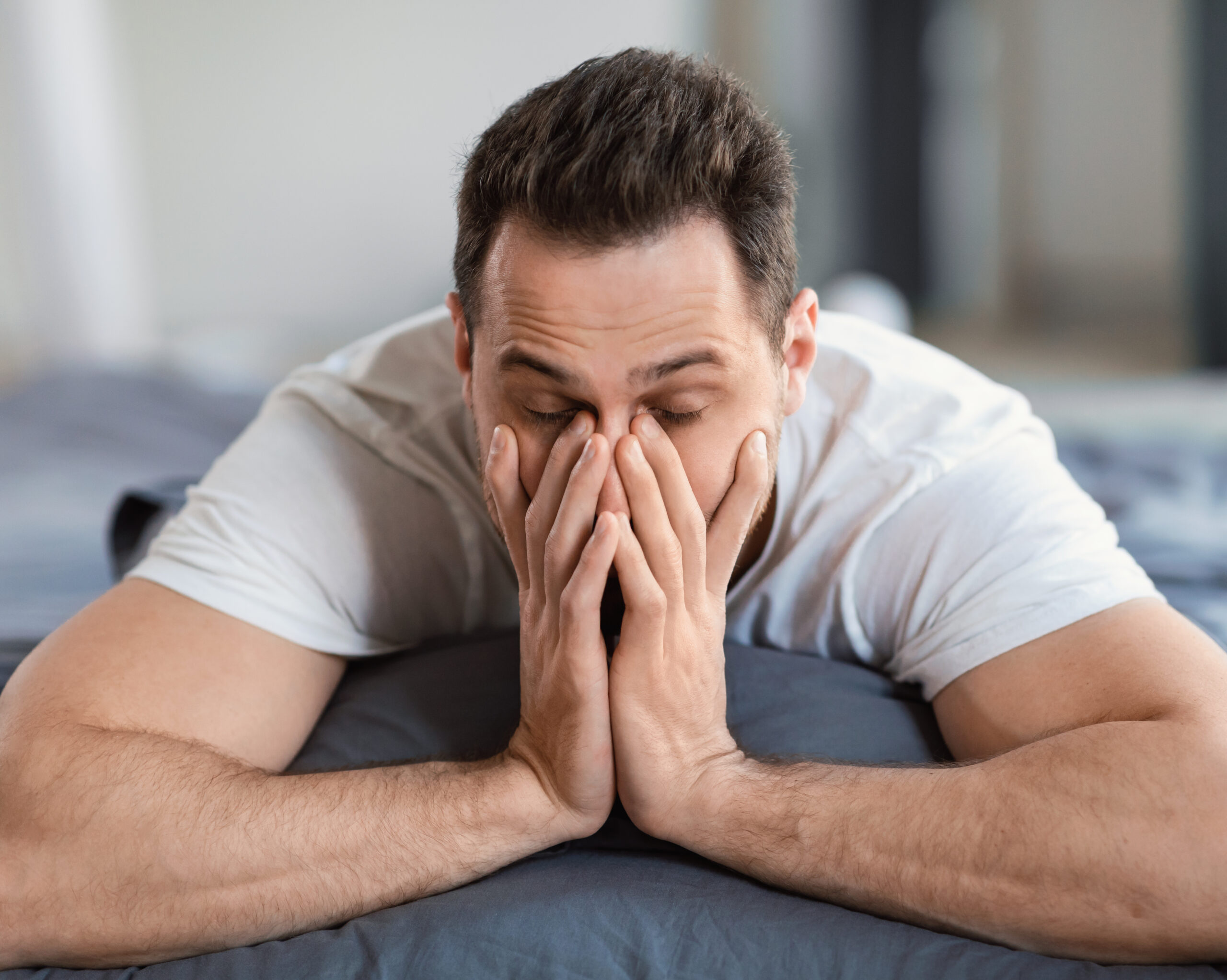 Man experiencing persistent fatigue, low energy, and poor sleep, common symptoms associated with hormone imbalance.